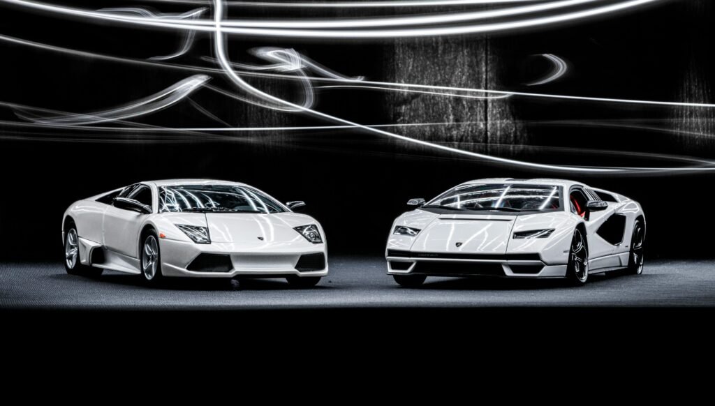 Elegant white Lamborghini Murcielago and Countach showcased with dynamic studio lighting.